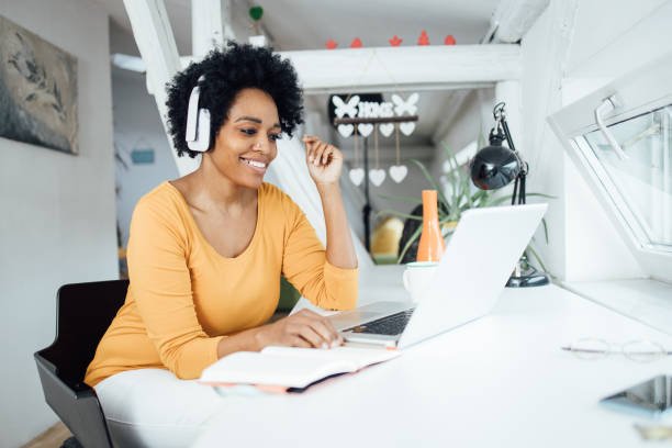 http://Portrait%20of%20a%20beautiful%20African-American%20woman%20listening%20to%20the%20music%20and%20enjoying%20at%20her%20home%20office.